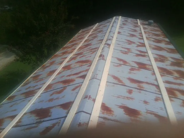 Rusted metal roof panels with new wood purlins before replacement — Storm Damage Roof Repair in Drury by Roofing Brothers