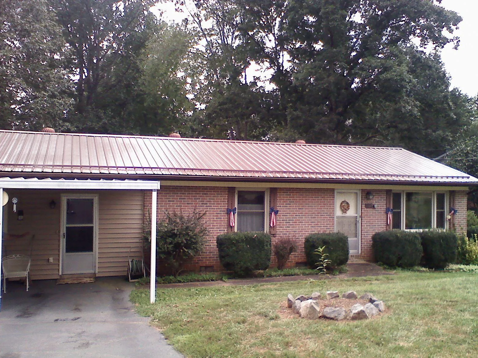Bronze metal roof and carport on a brick ranch home — Roof Repair work by our crew in Drury